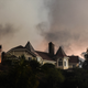 A wildfire burns close to a home in Santa Clarita on Saturday.